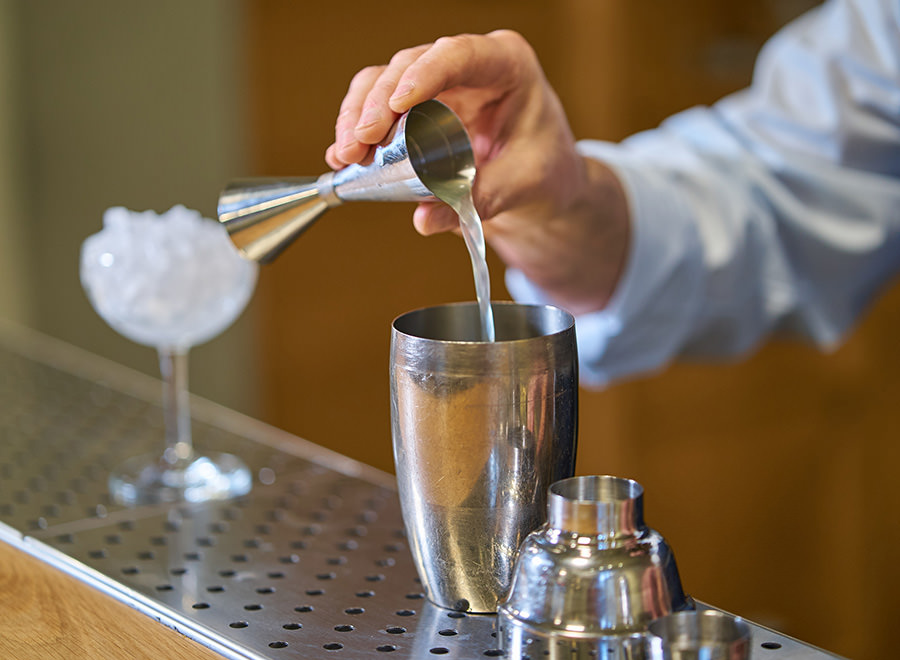un barman versa del liquido in uno shaker