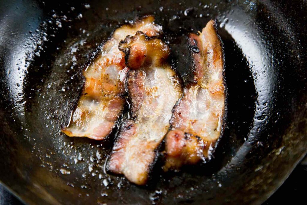Bacon viene cotto per recuperarne il grasso per fare il fat washing