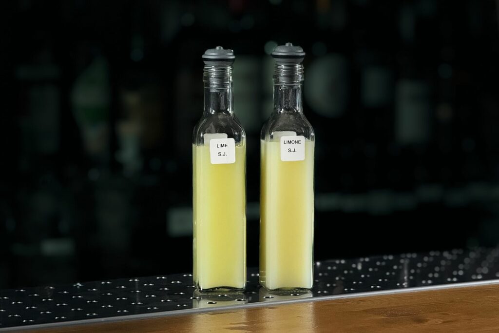 Su un banco bar, due bottigliette di forma quadrata, contenenti una preparazione denominata super Juice