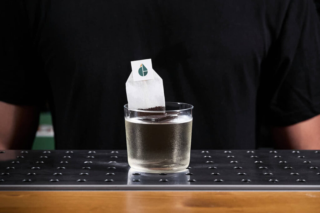 su un banco bar il cocktail "martini break". Una rivisitazione del martini cocktail che viene servito con una bustina di infuso (in questo caso olive e caffè) che il cliente può inserire nel cocktail per aromatizzarlo